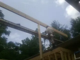 Carpenter setting a ridge beam over a new addition frame — Ice Dam Removal by Roofing Brothers in Ogunquit