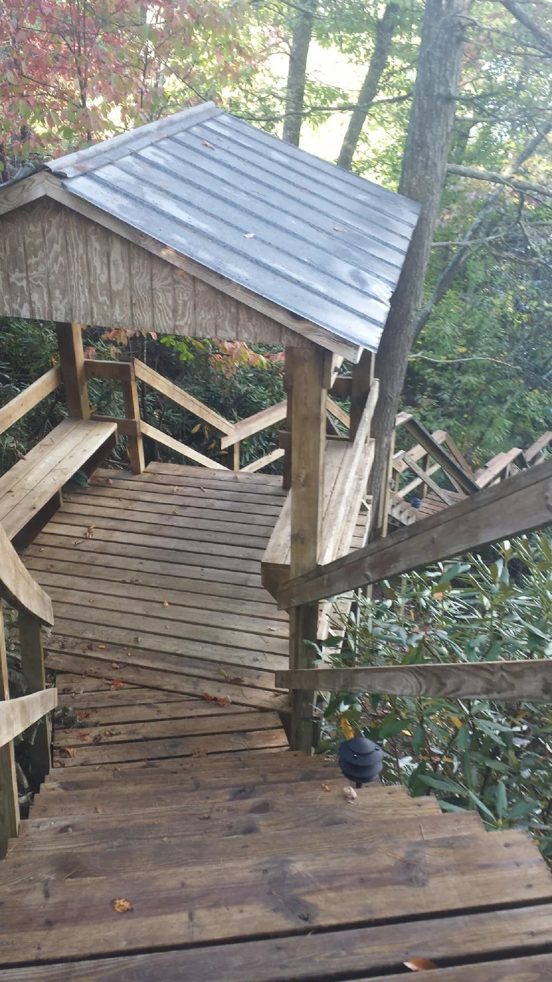 Metal roofed shelter over wooden steps on a wooded walkway — Skylight Repair & Installation work by our crew in Ogunquit