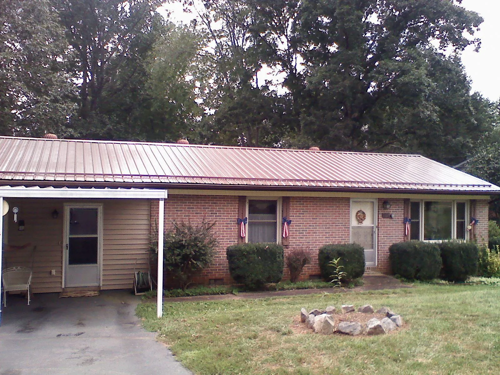 Bronze metal roof and carport on a brick ranch home — Roof Repair work by our crew in Ogunquit